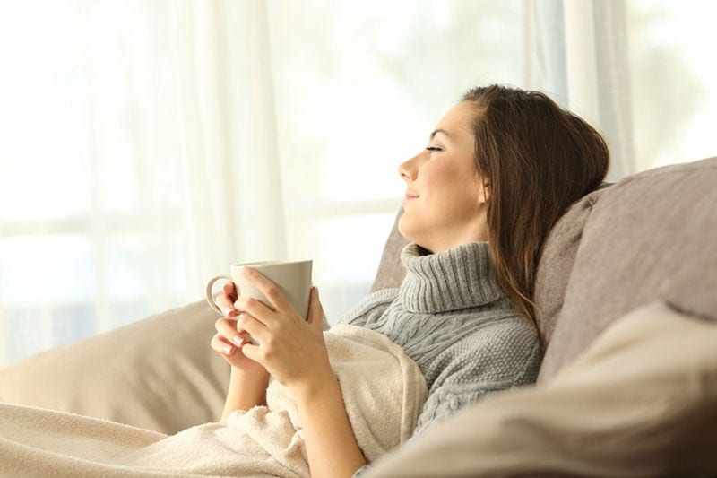 Pensive woman relaxing at home in winter.