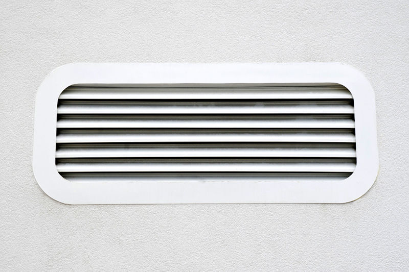 New white air conditioning vent on wall closeup.